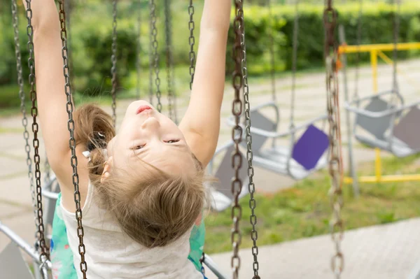 Junges Mädchen spielt auf einer Schaukel — Stockfoto