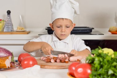 маленький хлопчик, навчання, щоб бути шеф-кухарем