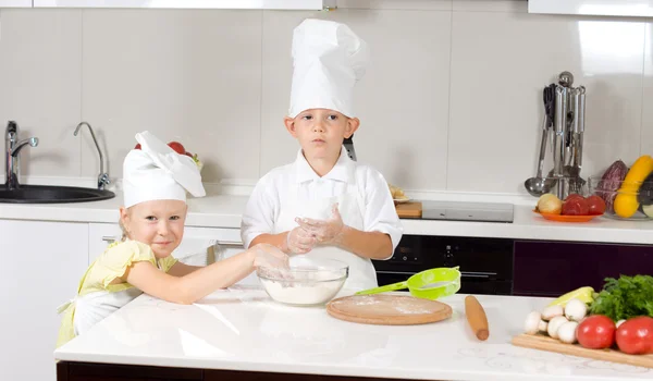 Schattige kleine chef-koks bakken in de keuken — Stockfoto
