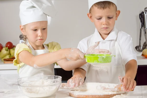 Мальчик и девочка пекут на кухне — стоковое фото