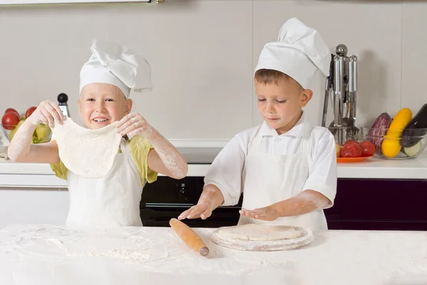 Два дуже молодих кухарів фліртують тісто для піци — стокове фото