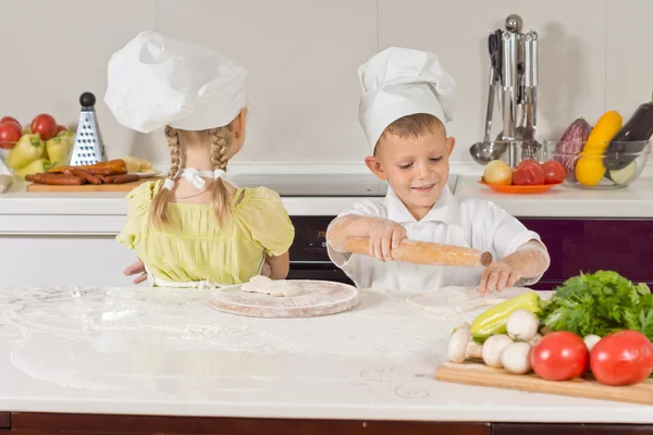 Zwei sehr junge Köche, die beim Reden Essen zubereiten — Stockfoto