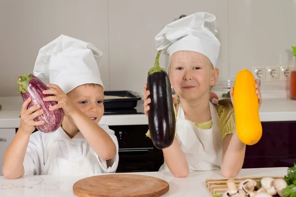 Schattige kleine chef-koks bedrijf enorme groenten — Stockfoto