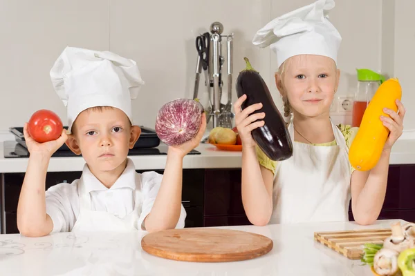 Twee chef-koks houden grote groenten — Stockfoto
