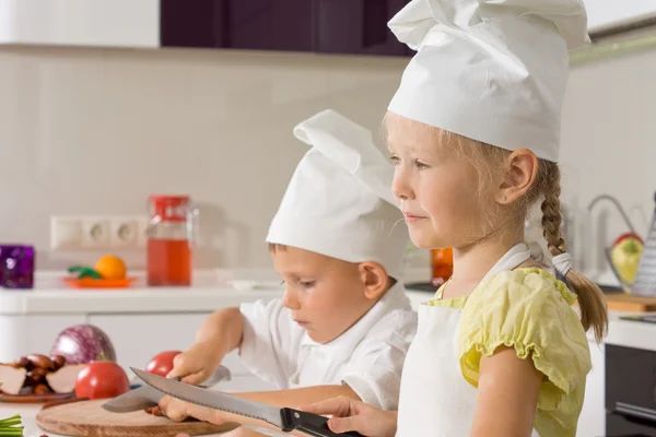 Small boy and girl cooking together in the kitchen — Stock Photo, Image
