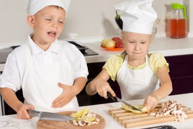 милий маленький шеф-кухаря нарізки піци інгредієнти