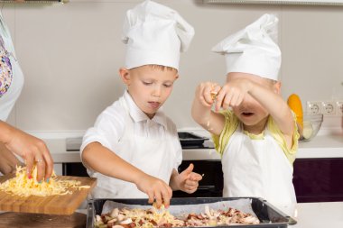 sevimli küçük pizza üzerine koyarak peynir çocuklar