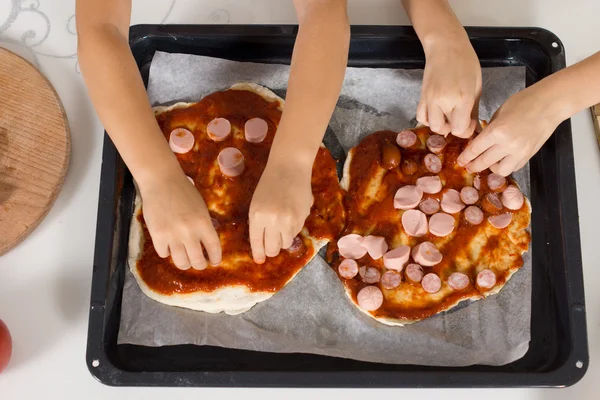 Deux petits enfants se font une pizza — Photo