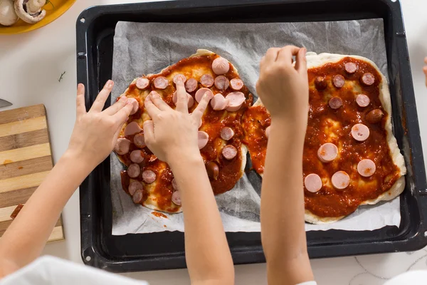 Two young children making homemade pizza — Stock Photo, Image