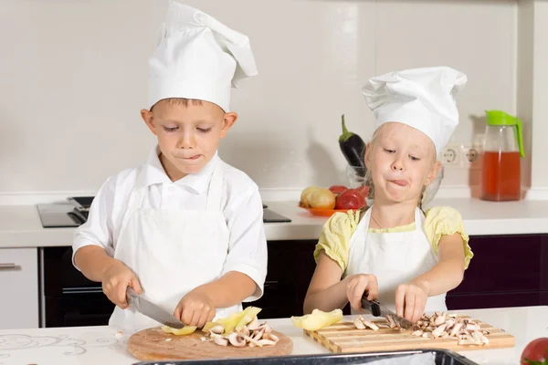 Kid Chefs Ingredientes de fatiamento ocupados na cozinha — Fotografia de Stock