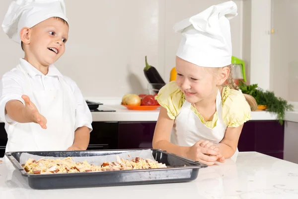 Biały dzieci w fartuch wykonane pizzy — Zdjęcie stockowe