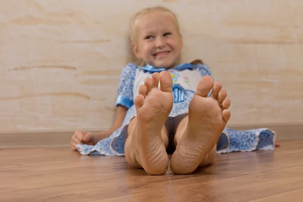 Sorrindo menina mostrando pés na câmera — Fotografia de Stock