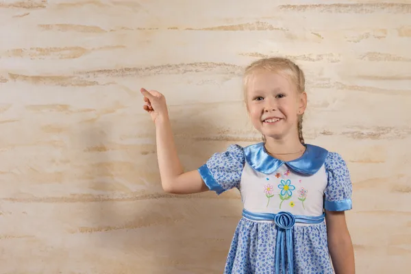 Schattig jong meisje in jurk geïsoleerde houten muur — Stockfoto