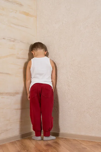 Petit garçon blanc face aux murs en bois — Photo