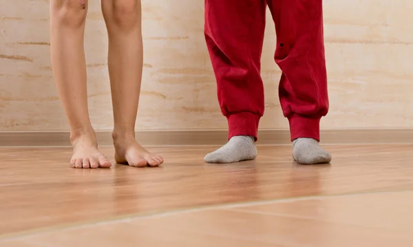 Dois pequenos pés de crianças no chão de madeira — Fotografia de Stock