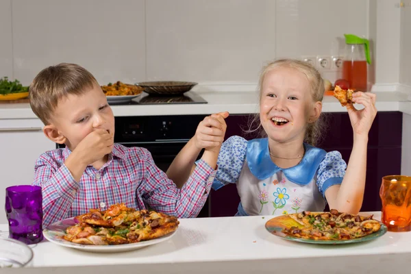 Dos niños celebrando comiendo su pizza —  Fotos de Stock