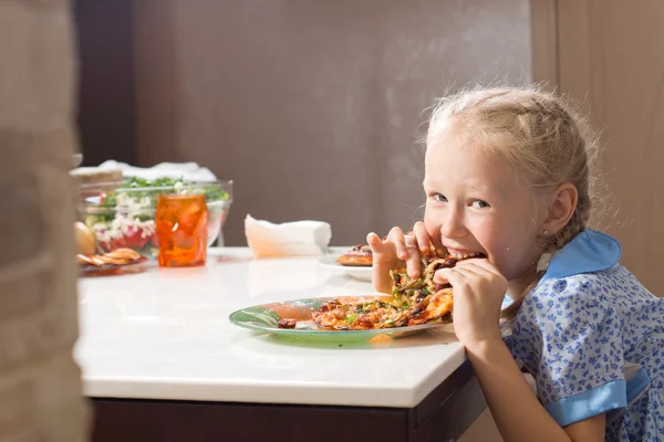 Głodny całkiem mała dziewczynka pożera pizzę domowej roboty — Zdjęcie stockowe