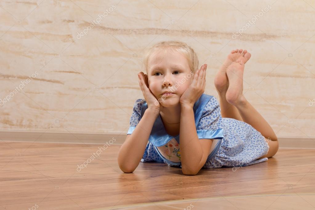 bored little girl lying on the wooden floor stock photo baby on bored