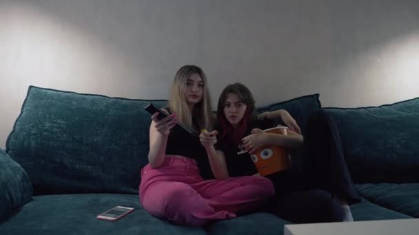 Två unga kvinnor fascinerade av ett TV-program — Stockvideo