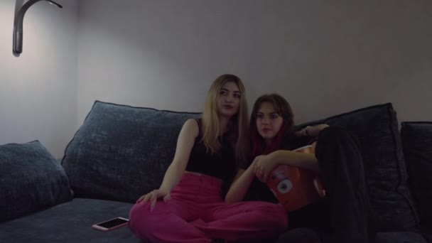 Twee jonge vrouw kijken naar een tv-programma 's nachts — Stockvideo