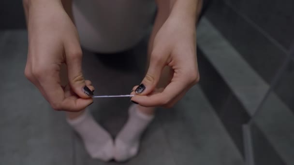 Жінка сидить на туалеті сміючись шматочком струни — стокове відео