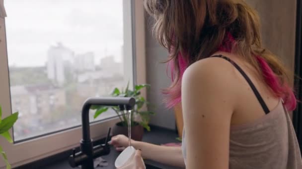 年轻的少女喝咖啡后正在冲洗杯子 — 图库视频影像