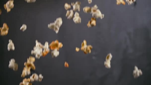 Розмитий фон, що падає свіжозроблений попкорн над сірим — стокове відео