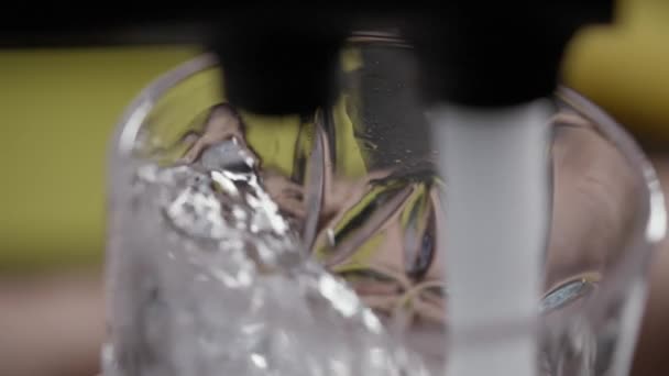 Вода, брызгающаяся в высокий стакан из крана или крана — стоковое видео