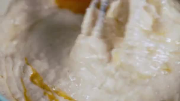 Egg beater in a mixture of flour and raw eggs in baking concept — Stock Video