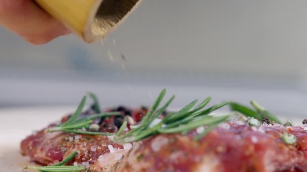 Cocinar condimento carne cruda con pimienta molida de un molino — Vídeos de Stock