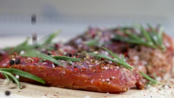 Låg vinkel syn på rått marmorerat kött kryddat med örter och krydda — Stockvideo
