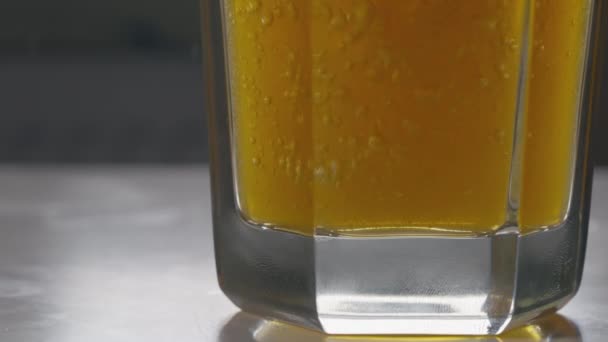 Vista de ángulo bajo de la parte inferior de un vaso de cerveza con cerveza — Vídeos de Stock