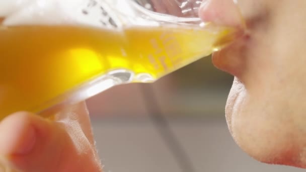 Close-up op de mond van een man drinken van een glas bier — Stockvideo