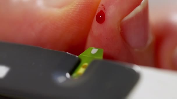 Diabetiker zieht ein Tröpfchen Blut, um den Glukosespiegel zu testen — Stockvideo