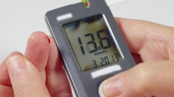 Diabetisch controleren van hun bloedglucosespiegels op een glucometer — Stockvideo