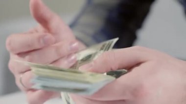 Kalın bir tomar para sayan bir adamın elleri.