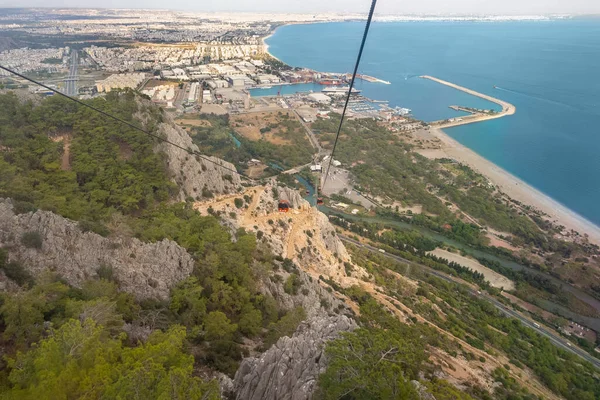 Elevated view of a city from a cableway at the top of a mountain looking down to the harbour and coastline of the bay in a travel and tourism concept