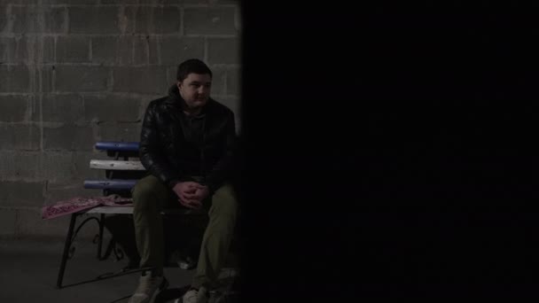 白人の男と黒人の男は爆弾の避難所に座っていて 話をしている ウクライナのロシアの侵略 — ストック動画