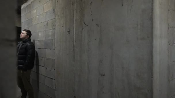 Blick in einen Keller mit kaukasischen Typen und schwarzen Typen, die sich während eines Bombardements unterhalten — Stockvideo