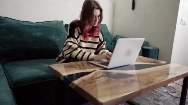 Genç bir kadın evinde oturmuş dizüstü bilgisayarla çalışıyordu.