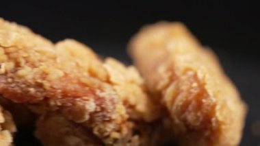 Selective focus to a piece of crumbed deep fried food, possibly chicken, in a close up view