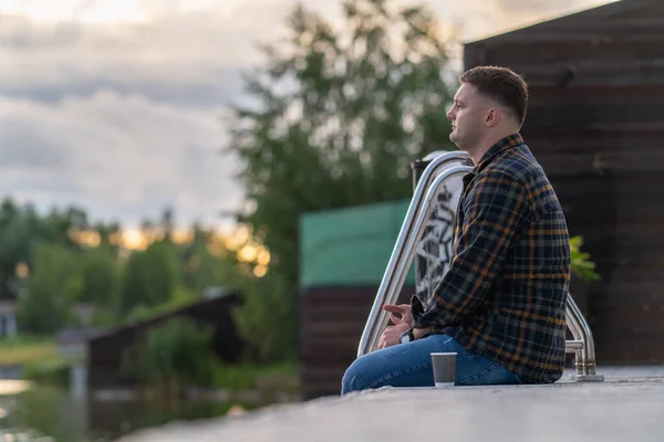Молодой Человек Сидящий Деревянной Набережной Закате Наслаждающийся Тихой Чашкой Кофе — стоковое фото