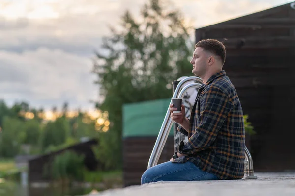 Profile Portrait Young Man Sitting Wooden Jetty Drinking Coffee Watching — kuvapankkivalokuva