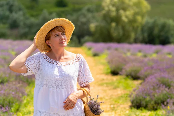 Thoughtful Mature Woman Walking Field Lavender Holding Her Straw Sunhat — Zdjęcie stockowe