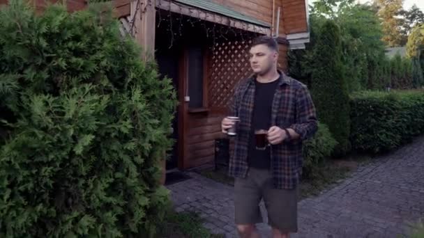 Mladý Muž Nese Kávu Pije Pěšině Před Domem Venkovského Dřeva — Stock video