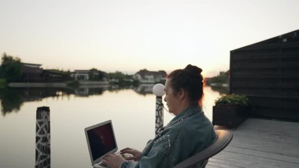 Middelbare Vrouw Zit Typen Een Laptop Bij Zonsondergang Buiten Een — Stockvideo