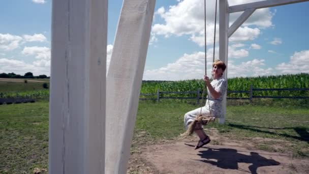 Pretty Middle Aged Woman Swinging Outdoor Swing Backdrop Maize Growing — Stock video