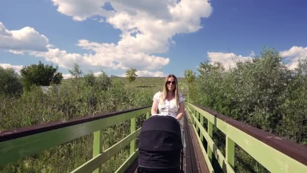 Mother Pushing Baby Stroller Bridge Receding Perspective Colorful Yellow Railings — Stockvideo