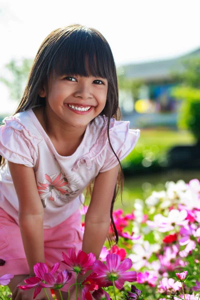 Азиатская маленькая девочка, стоящая с руками на коленях на лугу, Outd — стоковое фото