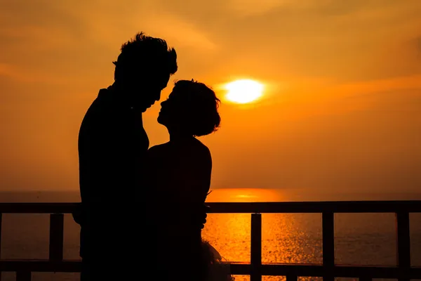 Couple silhouette on the beach at sunset — Stock Photo, Image